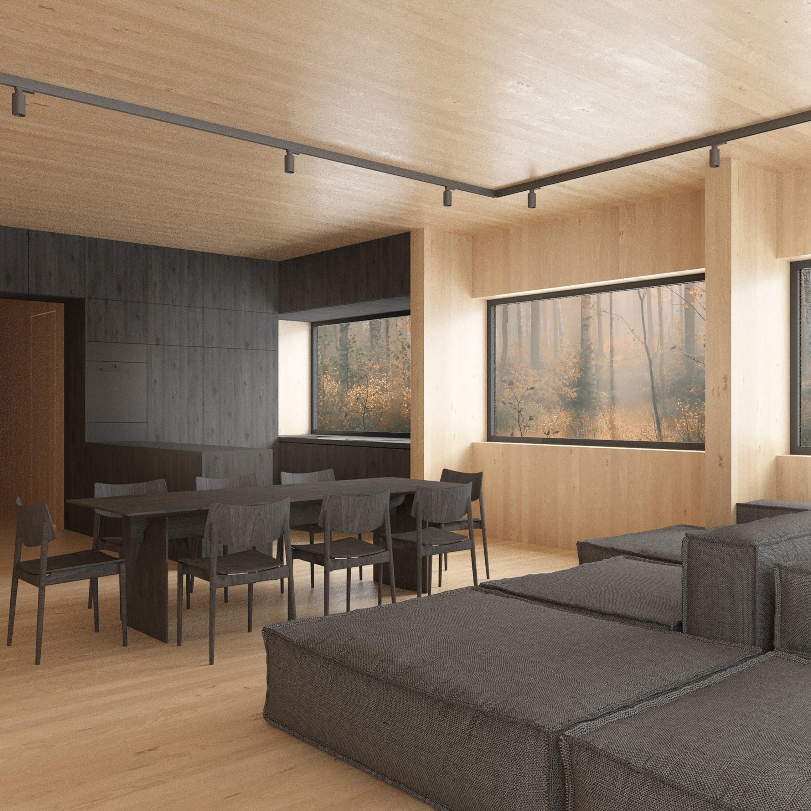 Modern interior of light wood. In the foreground is a gray modular sofa, further on a dark table with chairs. The windows overlook the autumn forest.