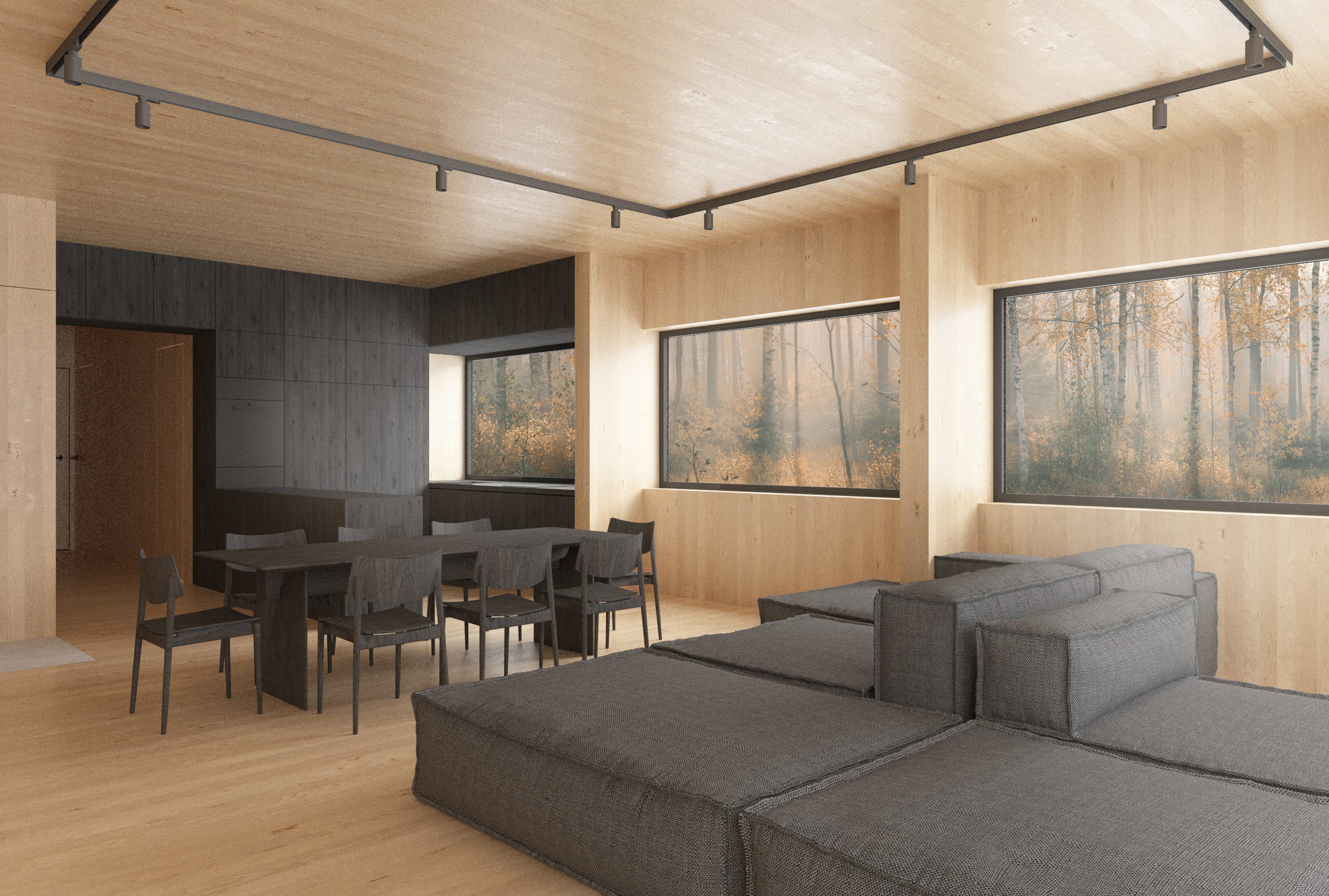 Modern interior of light wood. In the foreground is a gray modular sofa, further on a dark table with chairs. The windows overlook the autumn forest.