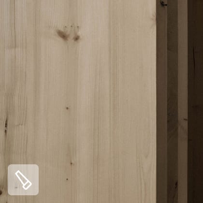 Wnętrze sauny wykończone jasnym drewnem, z czarnym piecem na drewno i dużym oknem, za którym widać ośnieżony krajobraz.