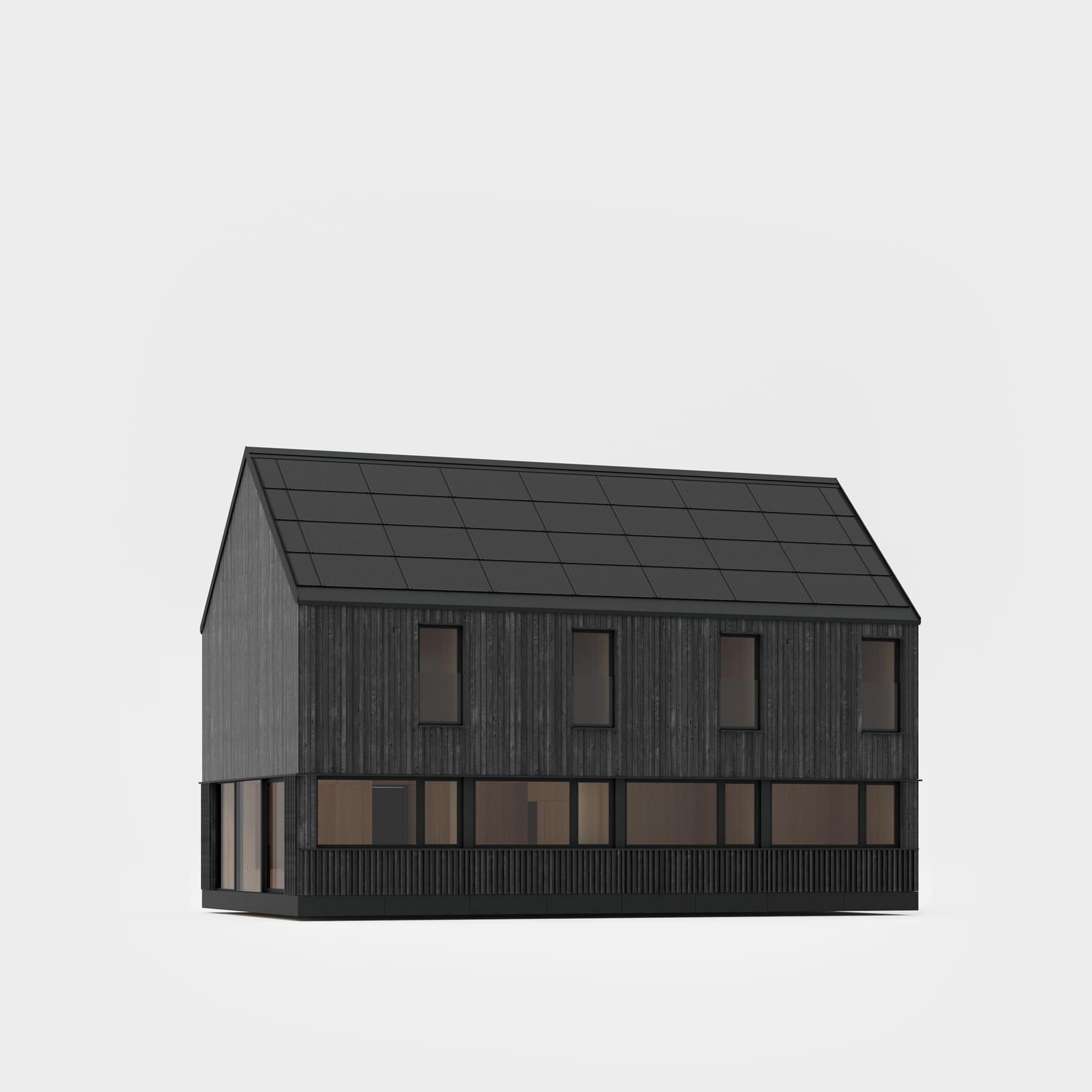 A dark, modern house with a roof entirely covered with photovoltaic panels, standing on a meadow at the foot of forested mountains.