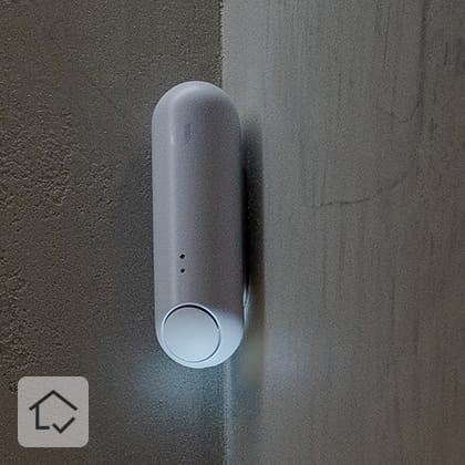 Close-ups of a textured, beige wall, with a white, oblong sensor mounted in the corner in the central part.