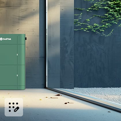 A green energy storage unit stands outside against a concrete wall covered with ivy.