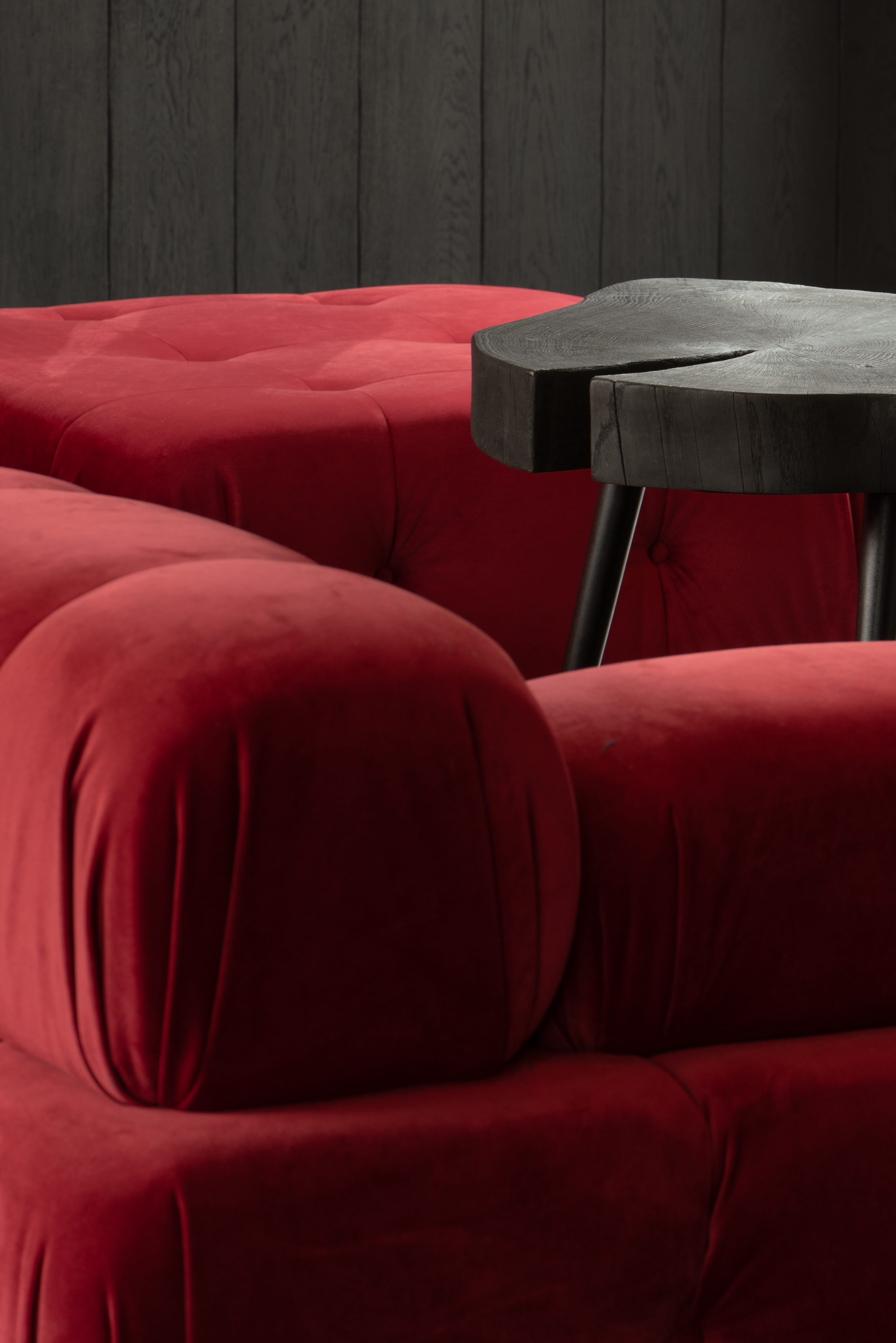 A red sofa and a dark wooden table in a Hombee home.