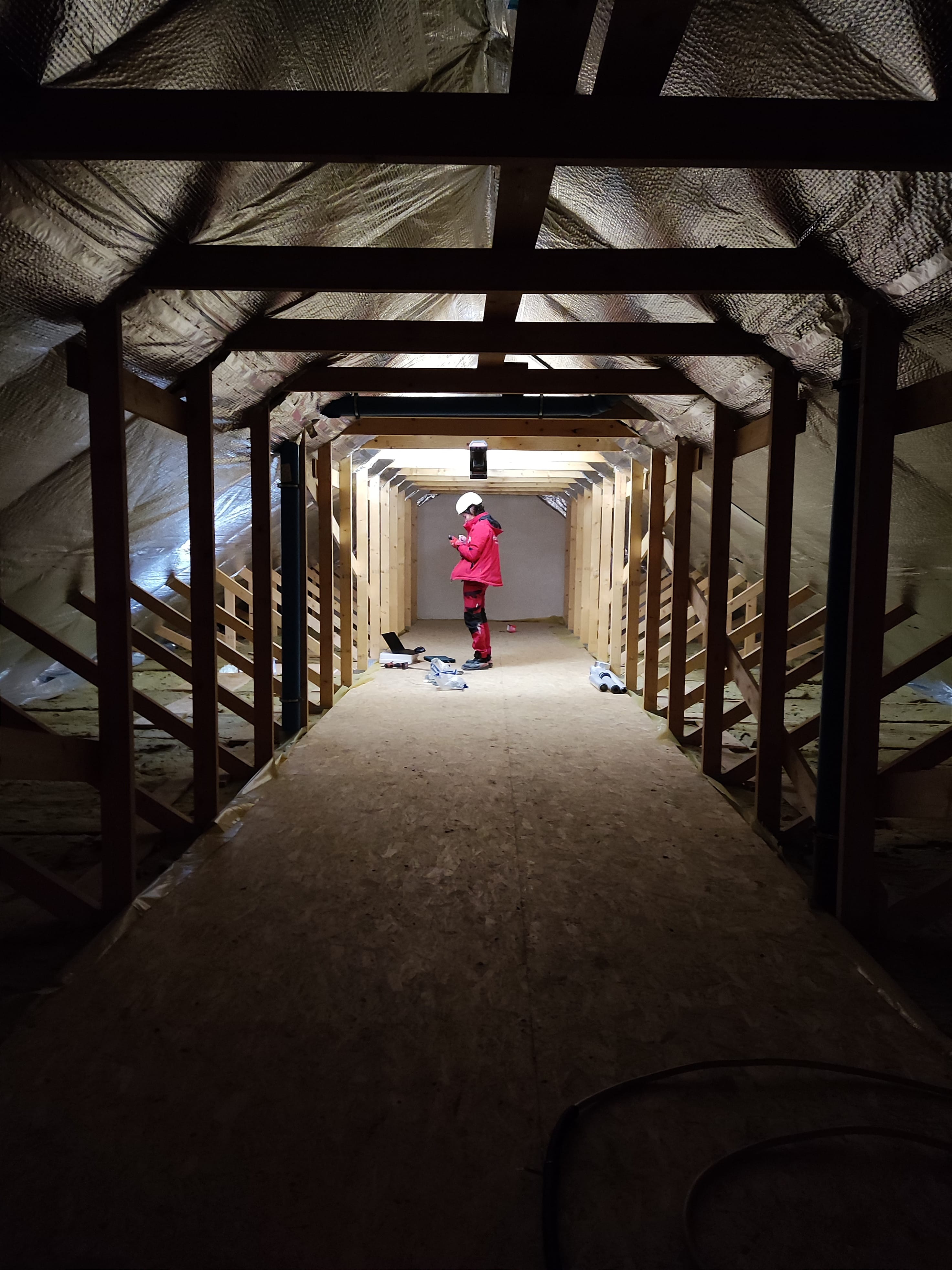 A Hombee specialist inspecting the timber roof structure and insulated attic during construction.